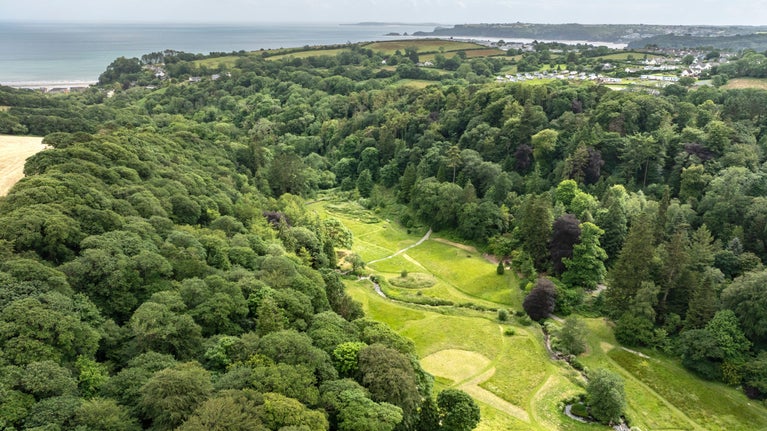 Aerial view of Colby Woodland Garden with coast in the distance